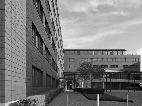 Innenhof zwischen zwei Gebäudeflügeln mit überdachtem Verbindungsweg